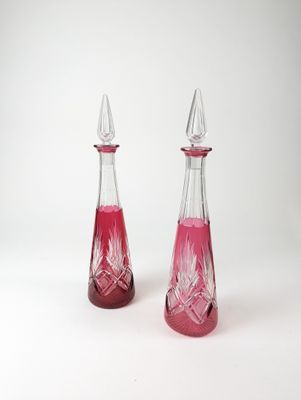 deux bouteilles en verre contenant un liquide rouge, posées sur une surface blanche