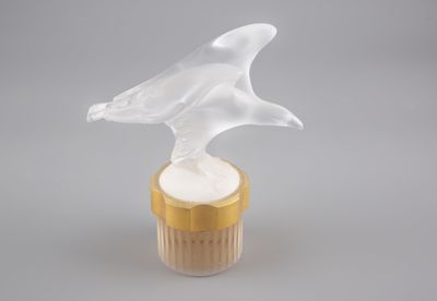 un oiseau en verre posé sur un cupcake