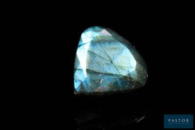 un gros plan d'une pierre de labradorite bleue sur une surface noire