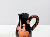 un vase noir et orange orné d'un cheval