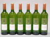 quatre bouteilles de vin sont alignées sur une surface blanche