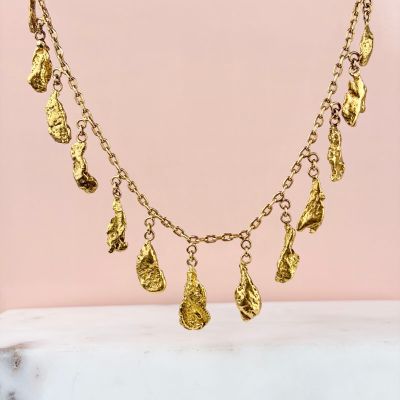 a gold plated necklace with five charms hanging from it