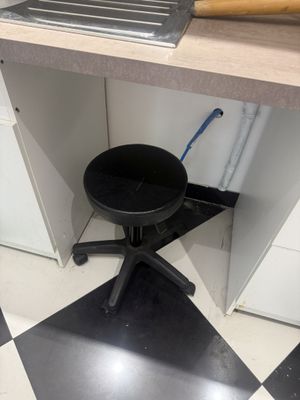 un sol à carreaux noirs et blancs dans une cuisine équipée d'un tabouret noir