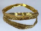 bracelet rigide plaqué or, au motif incurvé sur fond blanc
