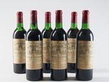 six bottles of wine are lined up on a white surface