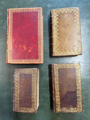 three old books sitting on top of a table next to each other
