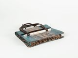 an old book with a wooden handle sitting on top of it