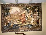 a tapestry on the wall of a room with a painting on it