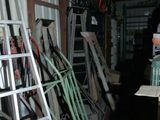 a ladder leaning against a wall next to a pile of tools