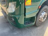 a green truck that has a yellow sticker on it