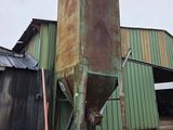 a green building that has a metal structure in front of it