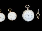 three different types of pocket watches on display against a black background