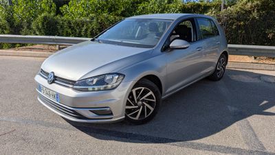 La Volkswagen Golf argentée est garée sur le bord de la route.