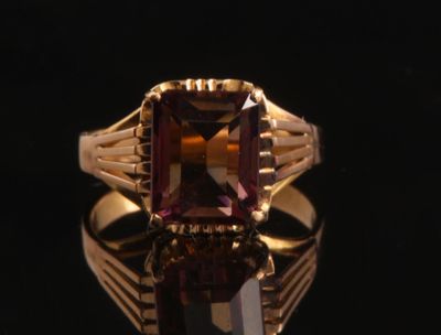 une image représentant une bague en or sertie d'une pierre violette