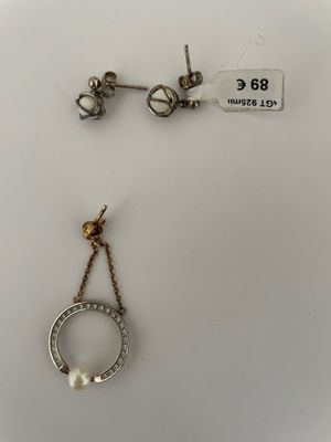 two pairs of earrings and a ring on a white plate