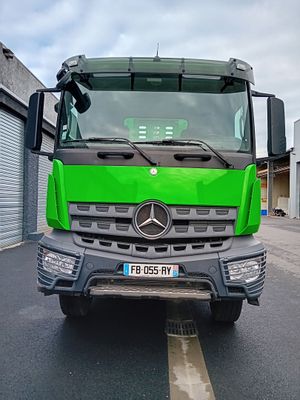 un camion vert garé devant un immeuble