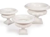 three white vases sitting next to each other on a white surface