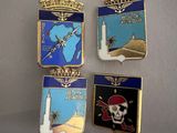 three lapel pins with a skull and a crown on them
