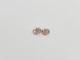 a pair of pink diamond earrings on a white surface