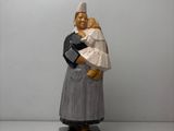 figurine d'une femme tenant un bébé dans ses bras