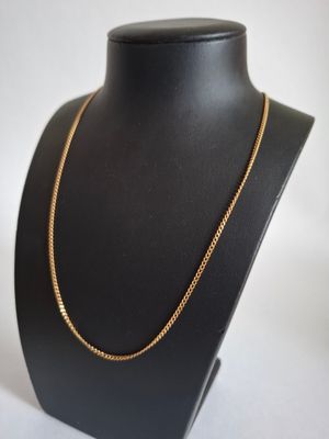 a black mannequin with a gold chain on it