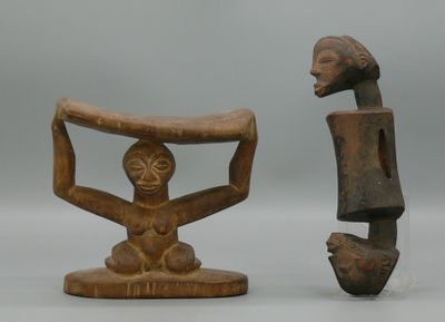 deux sculptures en bois représentant une femme et un homme tenant chacun un morceau de bois