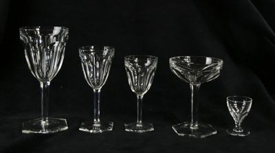 six wine glasses are lined up against a black background