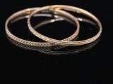 a close up of two gold rings on a black surface