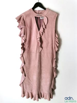 une robe rose suspendue à un cintre accroché au mur
