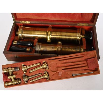 une boîte en bois contenant un télescope en laiton
