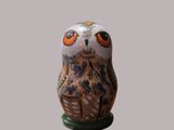 une petite figurine de chouette posée sur une table