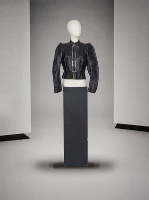 une photo d'un mannequin portant une veste et une jupe en cuir noir