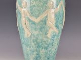 a green vase with two figures on it