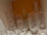 Des bouteilles et des verres sont alignés sur une étagère dans une pièce