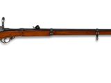 un vieux fusil accroché au mur, dont le canon est en bois