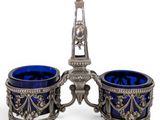 a pair of blue glass vases sitting on top of a metal stand