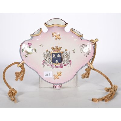 une assiette rose et dorée sur laquelle figure un blason
