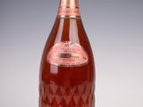 une vieille bouteille de vin posée sur une table blanche