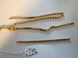 a close up of three gold chains on a white surface