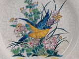 a plate with a bird and flowers painted on it