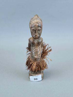 un gros plan sur une figurine représentant une personne portant une jupe en paille