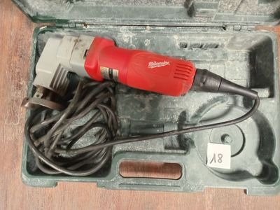 une perceuse électrique rouge dans un coffret posé sur une table