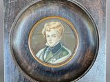 an old picture of a young man in a green coat