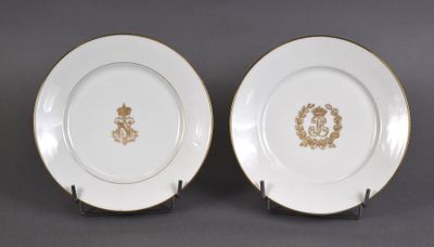 deux assiettes ornées de motifs dorés et blancs, posées sur une table
