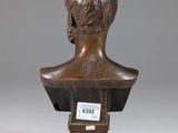 a bronze bust of a young man on a wooden base