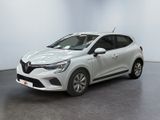Une voiture blanche est garée dans une pièce au sol noir.