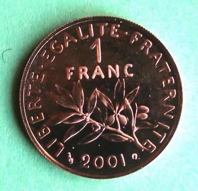 a close up of a one franc coin on a green surface