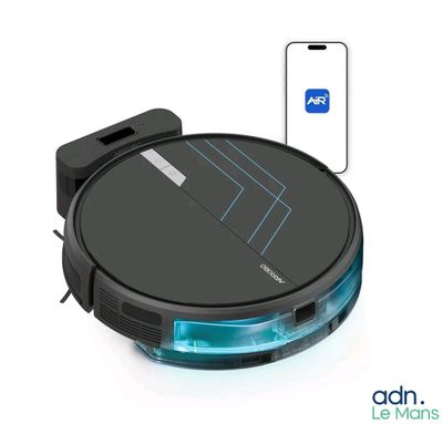 une photo d'un aspirateur robot avec un téléphone en arrière-plan