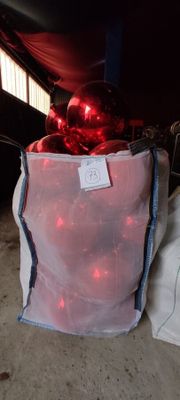 a bag with a red ornament in it sitting on the floor