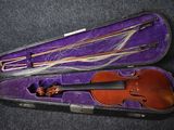 un violon dans un étui violet posé sur une surface noire